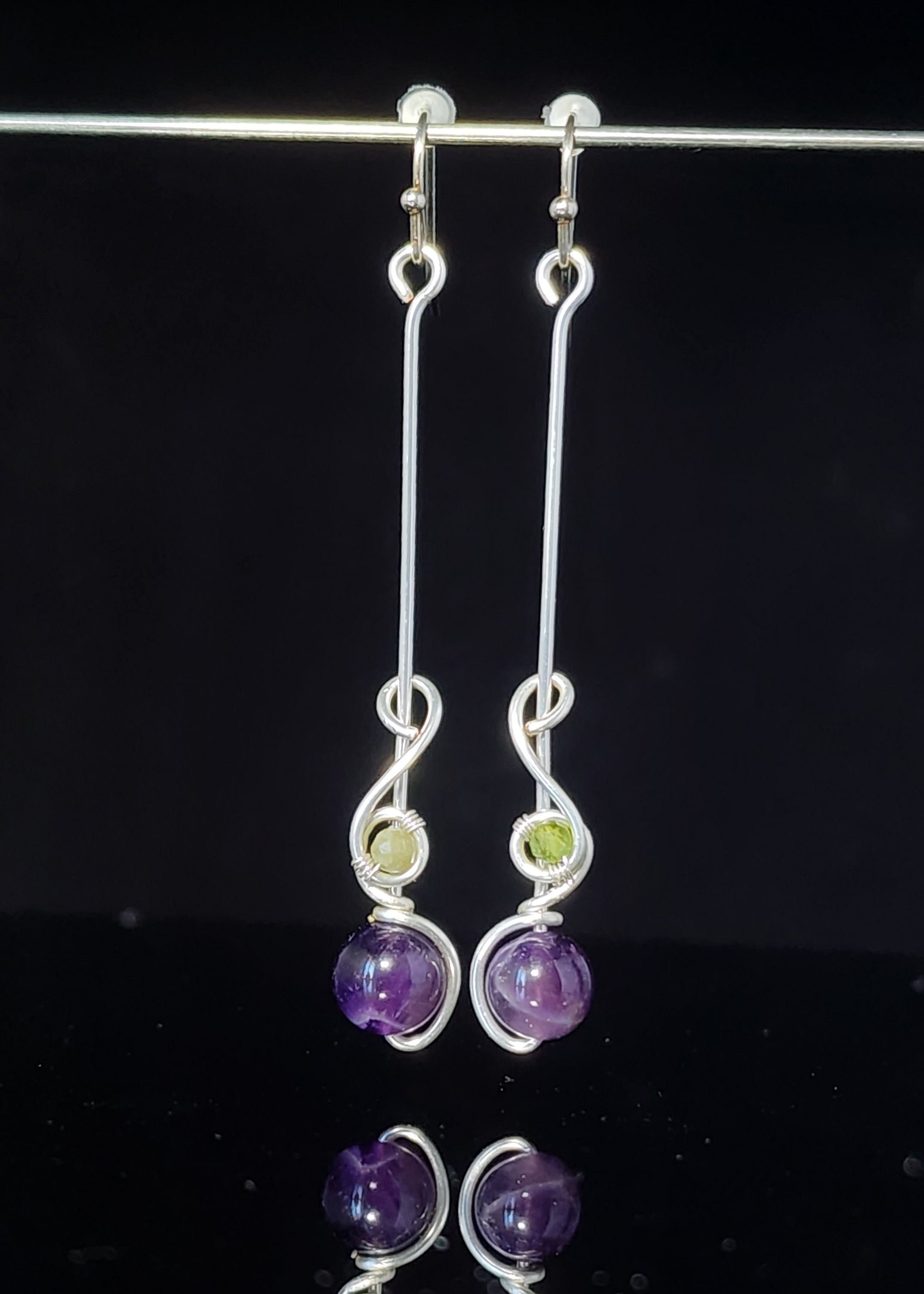 Amethyst Sphere and Tourmaline Bead Dangle Earrings Artist: Lindsey Griffin  Amethyst sphere wrapped in silver colored artistic wire with green tourmaline bead&nbsp;   2" long x 1/4" wide&nbsp;   Stirling silver wires   Beautiful dangle earrings   Cleaning instructions and cloth are included