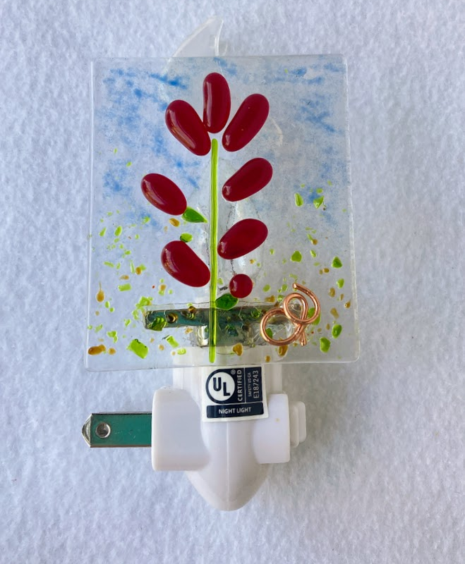 red indian paintbrush on a clear background. blue sky with green grass. fused glass nighlight