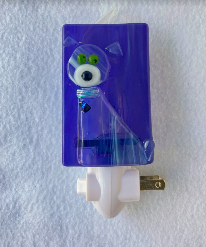 fused glass nightlight. purple dog with green eyes wearing a collar with a little bling. purple background