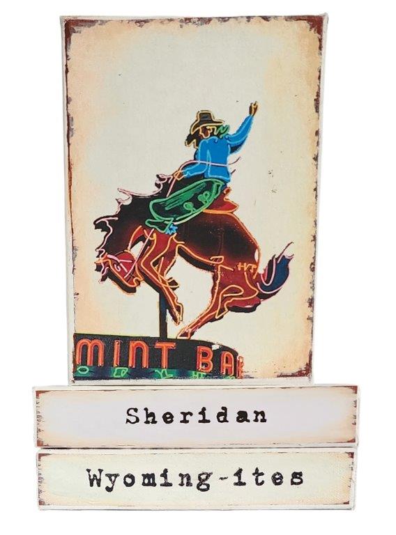 " Sheridan Wyoming-ites" Canvas Print Artist: Catherine Holt  Print on canvas with wooden framework   Copy from artists original  Neon sign of a bucking bronco and cowboy   Sheridan&nbsp; and Wyoming-ites label below.   Depiction of&nbsp; our Wyoming lifestyles and land history!  Perfect for a "Wyoming" Collection for your den or cabin  6" long x 8" high x 1 1/2" wide  Signed and numbered by the artist