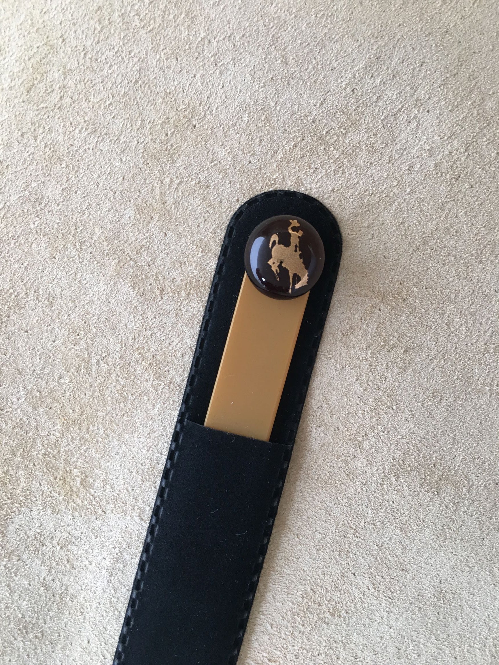 Spa quality glass nail file is accented with a round, fused glass dot with 22 kt gold foil of Steamboat, UWYO's bucking bronco logo. Comes in a faux velveteen sleeve.